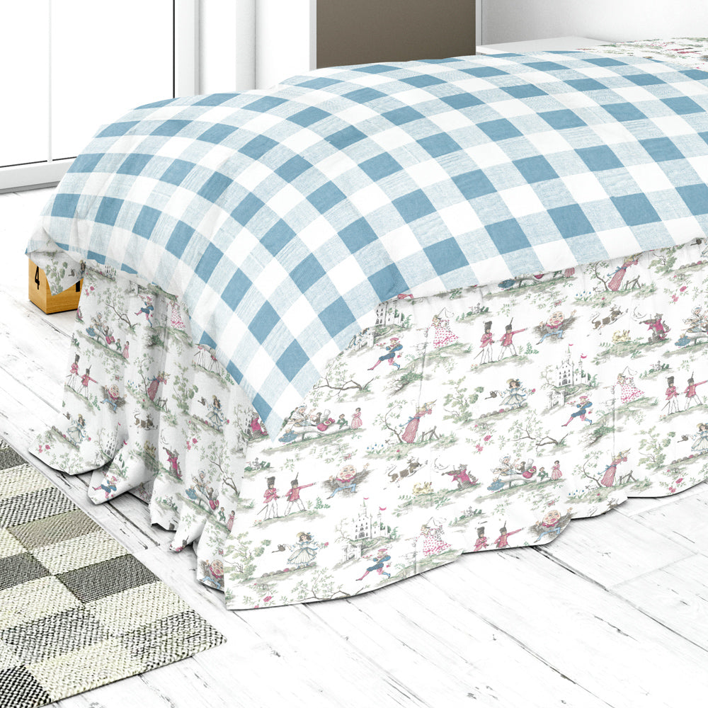 a bed with a blue and white checkered comforter and a matching bed skirt, placed on a white wooden floor.