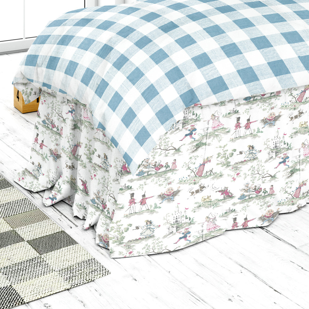 a bed with a blue and white checkered comforter and a matching bed skirt, placed on a white wooden floor.