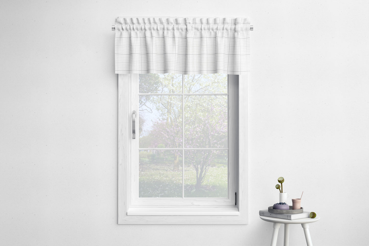 a white window with a white curtain, and a small table with a plant and a cup on it, set against a white wall.